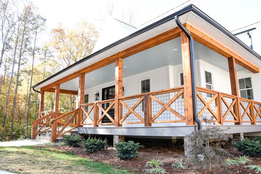 Custom home exterior with white siding, black windows, and wood beam accents by Ryan Noble Construction in North Carolina