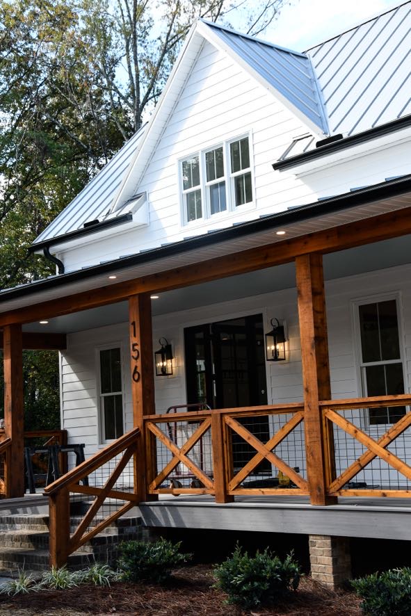 Custom home exterior with white siding, black windows, and wood beam accents by Ryan Noble Construction in North Carolina